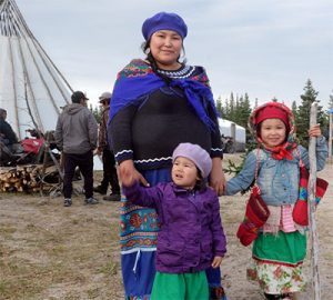 A mother holding the hands of her two daughters