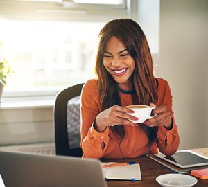 A businesswoman having coffee in front of her latptop